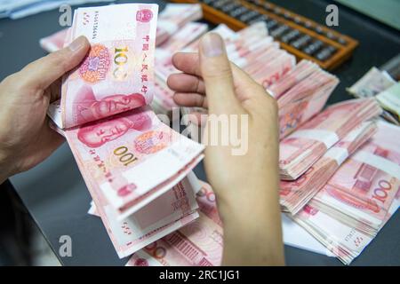 HAIAN, CHINA - 12. JULI 2023 - Ein Bankangestellter zählt chinesischen Yuan in Haian, Ostchina Provinz Jiangsu, 12. Juli 2023. Die chinesische Volksbank Stockfoto