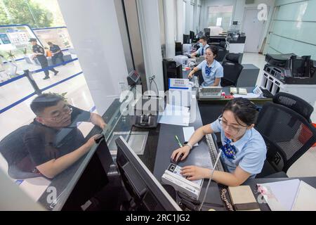 HAIAN, CHINA - 12. JULI 2023 - Ein Mitarbeiter einer Bank kümmert sich um persönliche Finanzdienstleistungen für Kunden in Haian, Ostchina Provinz Jiangsu, Jul Stockfoto