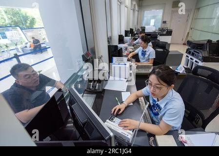 HAIAN, CHINA - 12. JULI 2023 - Ein Mitarbeiter einer Bank kümmert sich um persönliche Finanzdienstleistungen für Kunden in Haian, Ostchina Provinz Jiangsu, Jul Stockfoto