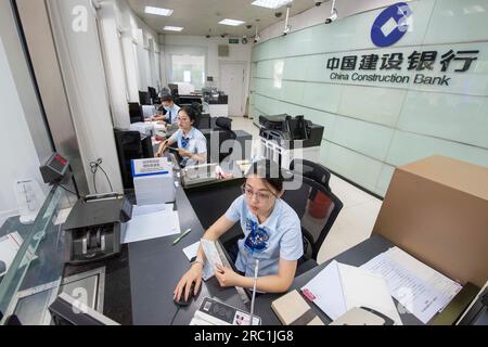 HAIAN, CHINA - 12. JULI 2023 - Ein Mitarbeiter einer Bank kümmert sich um persönliche Finanzdienstleistungen für Kunden in Haian, Ostchina Provinz Jiangsu, Jul Stockfoto