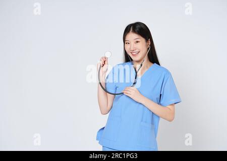 Junge Ärztin, die ein Stethoskop trägt, isoliert auf weißem Hintergrund. Stockfoto