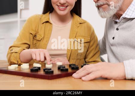 Dame spielen. Senior-Mann, lernende Frau am Tisch im Raum, Nahaufnahme Stockfoto