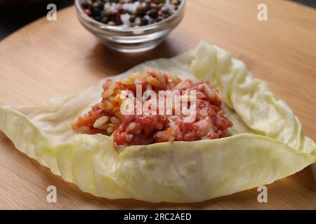 Ich bereite gefüllte Kohlrolle auf Holzbrett vor, Nahaufnahme Stockfoto