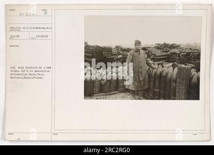 Sgt. 1. Klasse J.T. Seabrook aus South Carolina wird neben mehreren deutschen 210-mm-Artilleriegeschützen im Munitions Reclamation Depot Nr. 1 in Mauvages, Mause, Frankreich, fotografiert. Das Bild wurde am 12. Dezember 1918 aufgenommen. Stockfoto