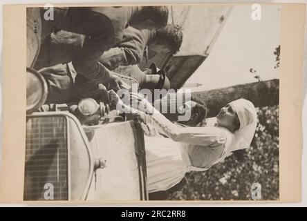 Soldaten marschierten im Ersten Weltkrieg durch ein Dorf. Mitglieder des amerikanischen Militärs können in Uniform gesehen werden, mit Gewehren und Helmen. Die Soldaten halten eine disziplinierte und organisierte Formation aufrecht, während sie sich vorwärts bewegen. Das Bild zeigt die Mobilisierung und Präsenz amerikanischer Truppen während des Krieges. Stockfoto