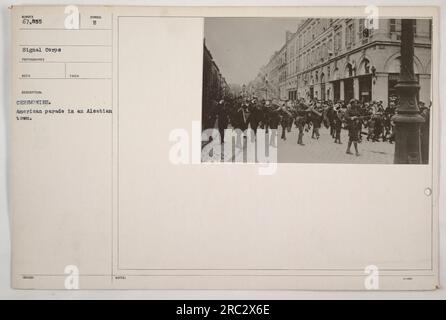 Das Foto zeigt eine amerikanische Militärparade, die während des Ersten Weltkriegs in einer elsässischen Stadt stattfindet. Die Anwesenheit von Soldaten und Zuschauern deutet auf ein feierliches oder Erinnerungsereignis hin. Das Bild wurde von den 67.855 Fotografen des Signalkorps aufgenommen, die eine Dokumentation der amerikanischen Militäraktionen während des Krieges lieferten. Das Foto wird als unter Symbol B aufgenommen beschrieben, das sich auf ein bestimmtes Ereignis oder eine bestimmte Aufgabe beziehen kann. Kontext und Zweck der Zeremonie sind in den verfügbaren Informationen nicht angegeben. Stockfoto