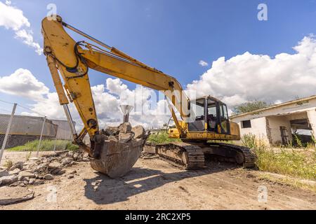 Raupenbagger auf Abbruchstelle. Vorderansicht eines großen Raupenbaggers, der auf einer Abbruchstelle arbeitet. Stockfoto