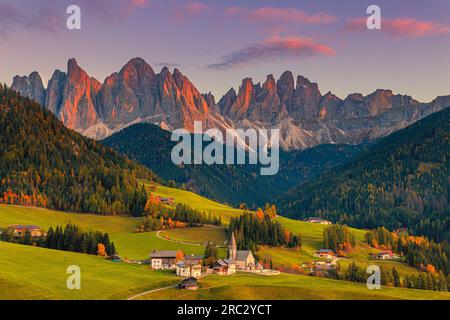 Ein Bild von einem herbstlichen Sonnenuntergang in der berühmten Kirche und dem Dorf Santa Maddalena vor den Geisler- oder Geisler-Dolomiten im Val di Stockfoto