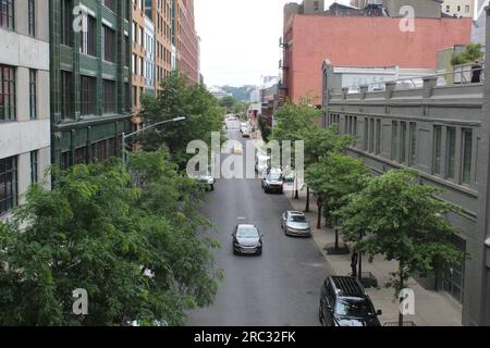 Ein Foto einer urbanen Straße in New York City mit vielen Autos, Gebäuden und Bäumen. Stockfoto