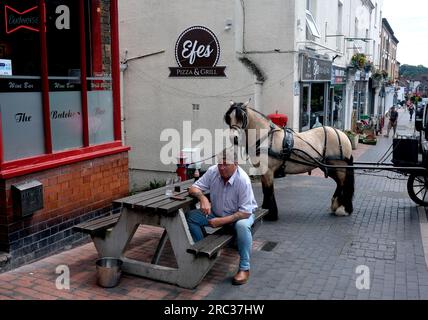 Ein Mann trinkt vor einer Bar mit gefesseltem Pferd und Kutsche neben dem Pub in Broseley, Shropshire. Großbritannien, Großbritannien. BILD VON DAVE BAGNALL Stockfoto