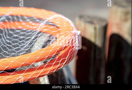 Detailbild von Tennisschlägern und Ball auf einem sehr verschwommenen Hintergrund, an einem sehr sonnigen Tag. Geringe Schärfentiefe. Wunderschöner Kontrast der Texturen. Stockfoto