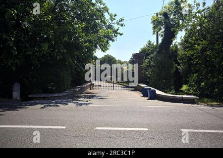 Tor am Eingang eines Herrenhauses, vom Rand einer Straße in der italienischen Landschaft aus gesehen Stockfoto