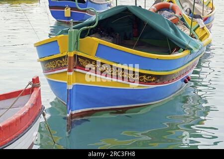 Charakteristisches luzzu, Maltas berühmtes Fischerboot, das im Hafen des Dorfes Marsaxlokk vor Anker liegt Stockfoto