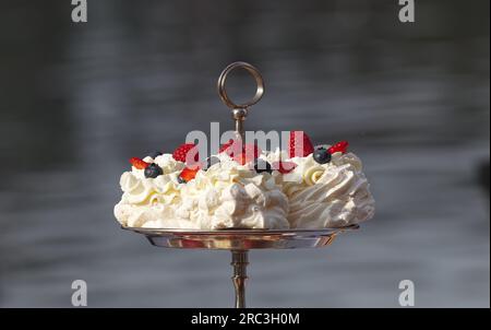 Pavlova-Desserts mit Sommerbeeren, Himbeeren, Erdbeeren und Blaubeeren verziert, ohne Menschen in der Nähe. Stockfoto