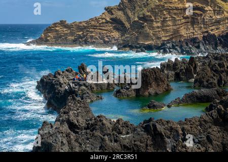 Touristen besuchen die natürlichen Meerwasser-Lava-Pools in Porto Moniz, Madeira, Portugal Stockfoto