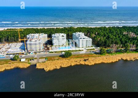 Kolberg, Polen, 20. April 2023: Luftaufnahme des Hotels Rogowo Pearl, das durch eine Baustelle erweitert wird, mit dem Binnenmeer im Vordergrund Stockfoto