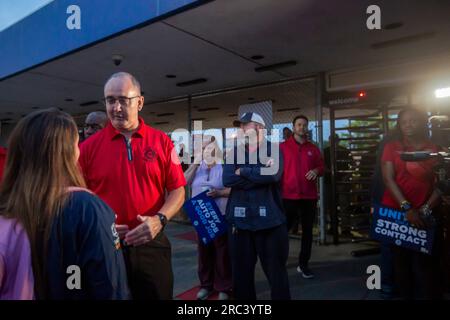 Sterling Heights, Michigan, USA. 12. Juli 2023. Shawn Fain, Präsident der Vereinten Automobilarbeiter, begann mit Ford, General Motors und Stellantis Vertragsverhandlungen, indem er Arbeiter vor den Toren des Montagewerks in Sterling Heights von Stellantis besuchte. Im Bruch mit der Tradition traf Fain sich mit UAW-Mitgliedern und schüttelte ihnen die Hand, anstatt eine formelle Händeschüttelzeremonie mit Führungskräften des Unternehmens abzuhalten. Autoverträge laufen am 14. September aus. Kredit: Jim West/Alamy Live News Stockfoto