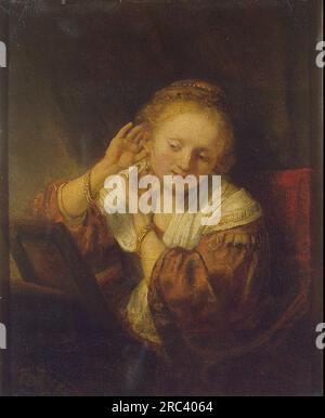 Junge Frau probiert Ohrringe 1654 von Rembrandt Stockfoto