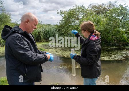 Dorney, Großbritannien. 12. Juli 2023. Die Bürgerwissenschaftler Dave und Jacqui Wallace, die im Auftrag der Henley River Action Group tätig waren, haben heute Tests der Wasserverschmutzung in Roundmoor Ditch (im Bild) in Dorney Common in Buckinghamshire mit Testgeräten von Earthwatch Europe durchgeführt. Die Überwachung der Dauer von Thames Water Event (EDM) zeigt, dass Themsenwasser aus den nahe gelegenen Kläranlagen für Thames Water Slough in den Roundmoor-Graben eingelaufen ist. Die letzte EDM-Einleitung wurde jedoch am 21. Januar 2023 erfasst. Die Ergebnisse der heutigen Tests auf dem trüben Wasser in Roundmoor Graben Stockfoto