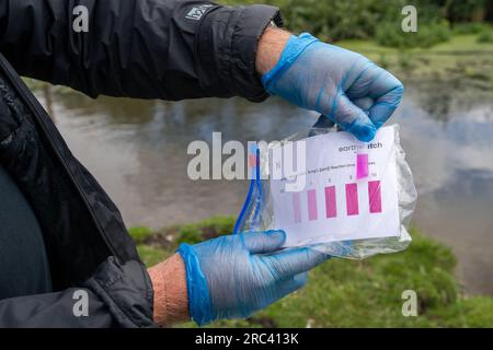 Dorney, Großbritannien. 12. Juli 2023. Die Bürgerwissenschaftler Dave und Jacqui Wallace, die im Auftrag der Henley River Action Group tätig waren, haben heute mit den von Earthwatch Europe bereitgestellten Testgeräten Tests zur Wasserverschmutzung in Roundmoor Ditch in Dorney Common in Buckinghamshire durchgeführt. Die Überwachung der Dauer von Thames Water Event (EDM) zeigt, dass Themsenwasser aus den nahe gelegenen Kläranlagen für Thames Water Slough in den Roundmoor-Graben eingelaufen ist. Die letzte EDM-Einleitung wurde jedoch am 21. Januar 2023 erfasst. Die Ergebnisse der heutigen Tests auf dem wolkigen Wasser in Roundmoor Graben fanden beides Stockfoto