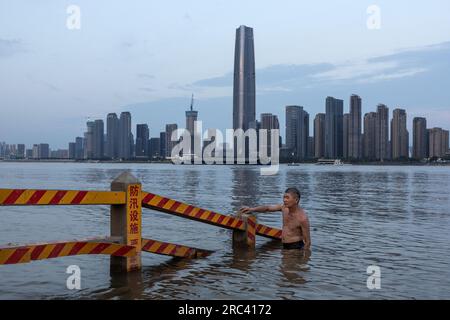 Wuhan, China. 11. Juli 2023. Ein Mann kühlt sich im Jangtse in Wuhan, in Chinas zentraler Provinz Hubei, ab. Der 11. Juli markiert den Beginn der traditionell als Chinas 40-tägige heiße und feuchte Jahreszeit, den Hundetagen des Sommers, bekannten Zeit. Am Dienstag verlängerte das National Meteorological Center eine orangefarbene Alarmstufe - die zweithöchste Alarmstufe - für hohe Temperaturen, während Hitzewellen riesige Teile des Landes verbrennen. (Foto: RenYong/SOPA Images/Sipa USA) Guthaben: SIPA USA/Alamy Live News Stockfoto