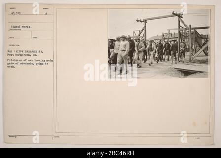 Kriegsgefangene verlassen das Haupttor der Kriegsgefangenenbaracke Nr. 1 in Fort McPherson, Georgia. Sie werden in Richtung Werkstor 45625 gesehen, unter Aufsicht des Signalkorps. Das Foto wurde während des Ersten Weltkriegs aufgenommen. Stockfoto