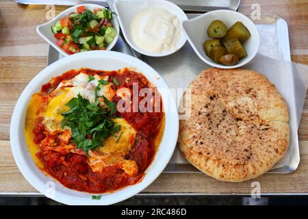 Israelische Küche. Shakshuka Lunch - pochierte Eier in scharfen, in der Pfanne gebratenen Tomaten. Stockfoto