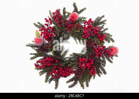 Festivals, religiös, Weihnachten, Kranz aus künstlichen Blättern und Beeren mit Pinienzapfen und Äpfeln. Festivals, Religiös, Weihnachten. Stockfoto