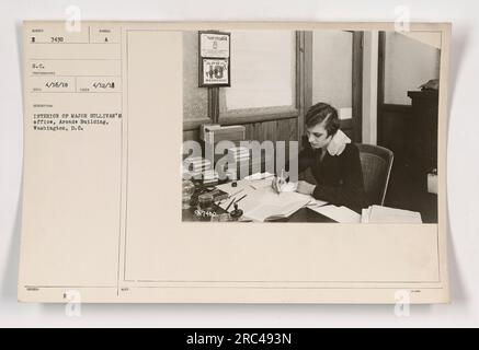 Innenansicht von Major Sullivans Büro im Arcade-Gebäude, Washington, D.C., aufgenommen am 12. April 1918. Das Foto zeigt die Büroumgebung mit Schreibtischen, Stühlen und militärischen Dokumenten. Das Bild stellt eine faktische Darstellung der Büroumgebung während des Ersten Weltkriegs dar. Stockfoto