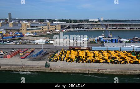 EWS Klasse 66 dieselelektrische Güterlokomotive Nr. 66083, die einen Autoträgerzug an den Southampton Docks steuert, mit gelben JCB's am Kai. Stockfoto