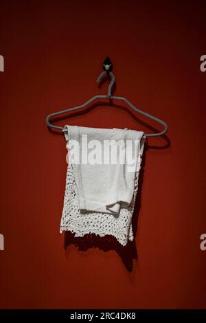 Das Handtuch hängt vor dem Hintergrund der roten Wand Stockfoto