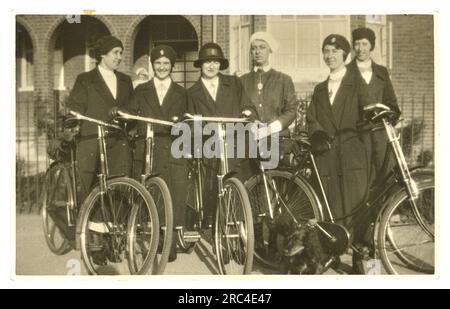 Originale Postkarte aus dem Jahr WW1 mit einer Gruppe von fröhlichen Bezirksschwestern mit Fahrrädern, die Abzeichen des Queen's Institute of District Nurses (QNI) auf Hüten tragen - arbeiten an der Heimatfront, um 1915, Großbritannien Stockfoto