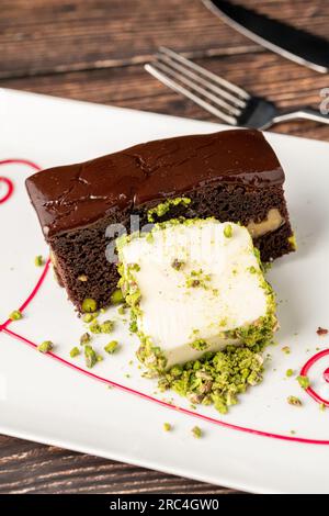 Köstlicher Brownie mit Vanilleeis auf einem weißen Porzellanteller Stockfoto