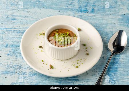 Soufflé mit Pistazien und Tahini auf einer weißen Porzellanplatte Stockfoto