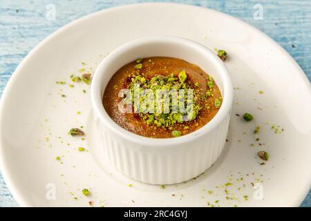 Soufflé mit Pistazien und Tahini auf einer weißen Porzellanplatte Stockfoto