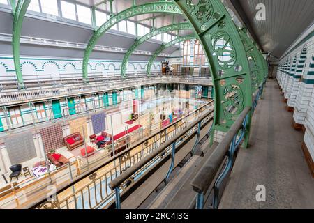 Birmingham, Großbritannien. 12. Juli 2023. Ein Swimmingpool aus dem Jahr 1907 ist die Heimat einer vorübergehenden Umwandlung in ein Wohnzimmer. Das Balsall Heath Gala Pool in der Innenstadt von Balsall Heath, Birmingham, bietet Kunstwerke, Teppiche und weiche Möbel, die einen willkommenen Ort für eine Tasse Tee und ein Gespräch bieten. Die Bäder der Moseley Road werden zur gleichen Zeit renoviert, um ihre edwardianischen Armaturen und Armaturen zu präsentieren. Kredit: Peter Lopeman/Alamy Live News Stockfoto