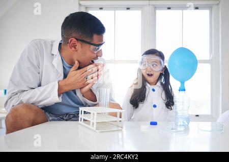 Wow, Bildung und ein Vater und ein Kind, die Wissenschaft, Innovation und Laborarbeit in einem Haus machen. Glücklich, Überraschung und ein junger Vater, der ein Experiment macht Stockfoto