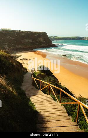 Von oben über einem hölzernen Pier mit Geländern und Sandstrand in der Nähe des Wellenmeers bei klarem Wetter im Hintergrund bei wunderschönen Naturausflügen Stockfoto