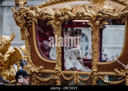 König Charles und Königin Camilla lächeln, während sie sich nach der Krönung auf den Weg zurück zum Buckingham Palace machen. Stockfoto