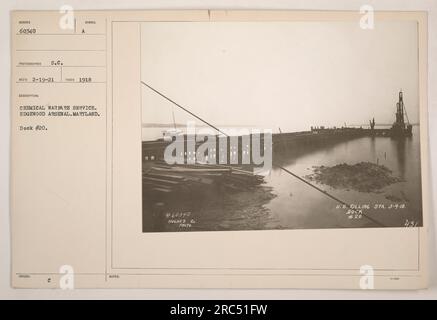 Die Abbildung zeigt Dock Nr. 20 am Edgewood Arsenal in Maryland, das vom Chemical Warfare Service während des Ersten Weltkriegs genutzt wurde. Das Foto wurde 1918 vom Fotografen S.C. aufgenommen und erhielt es am 19. Februar 1921. Das Bild zeigt das Zeichen für den Chemical Warfare Service und die Kennung „60340“. In der Überschrift wird auch erwähnt, dass das Foto von A.C. herausgegeben wurde und zusätzliche Notizen enthält, die auf das Foto der Hughes Company und die US-Tankstelle am 9. März 1918 an Dock Nr. 20 verweisen. Stockfoto