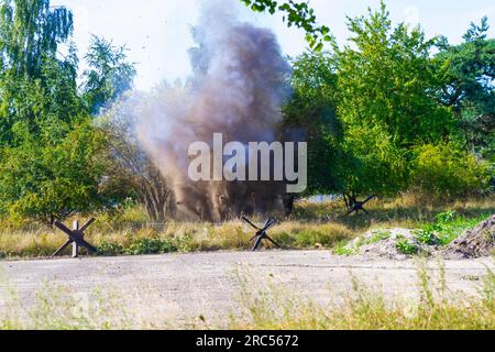 Hintergrund. Bombe explodiert zwischen den Bäumen. Wiederaufbau der Schlacht aus dem Zweiten Weltkrieg. Stockfoto