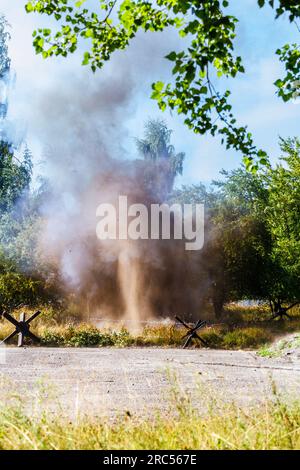 Hintergrund. Bombe explodiert zwischen den Bäumen. Wiederaufbau der Schlacht aus dem Zweiten Weltkrieg. Stockfoto