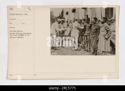 Französische Offiziere verleihen mutigen verwundeten Soldaten im Afrikanischen Krankenhaus im Ersten Weltkrieg militärische Auszeichnungen. Dieses Foto mit der Bezeichnung 111-SC-1573 ist Teil der offiziellen Sammlung der französischen Regierung (SUMBER 1573). Der Fotograf für dieses Bild war RDCD, und es wurde vom Militär aufgenommen und herausgegeben. Stockfoto