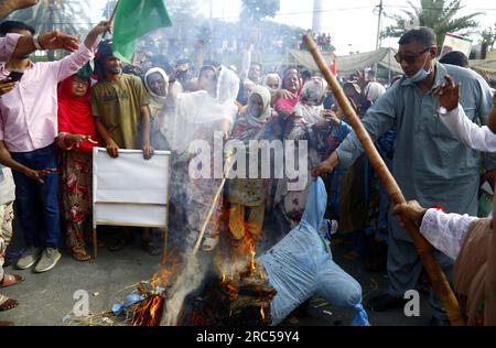 Hyderabad, Pakistan, 12. Juli 2023. Bewohner von Lyari blockieren Straße und verbrennen Statue, während sie Protestdemonstration gegen den längeren Stromabwurf und Überabrechnung durch K-Electric, außerhalb der K-Electric Zentrale in Karatschi am Mittwoch, den 12. Juli 2023 halten. Stockfoto