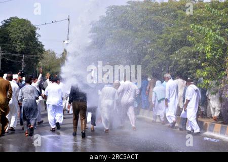 Hyderabad, Pakistan, 12. Juli 2023. Sicherheitsbeamte stellen den Baton-Angriff wieder her, benutzten Wasserkanonen und Verhaftungen, um Demonstranten abzuwehren, während sie sich während der Protestdemonstration der All Sindh Primary Teachers Association for Regularization am Mittwoch, den 12. Juli 2023 in Karatschi auf den Weg zum CM House bewegen. Stockfoto