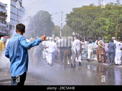 Hyderabad, Pakistan, 12. Juli 2023. Sicherheitsbeamte stellen den Baton-Angriff wieder her, benutzten Wasserkanonen und Verhaftungen, um Demonstranten abzuwehren, während sie sich während der Protestdemonstration der All Sindh Primary Teachers Association for Regularization am Mittwoch, den 12. Juli 2023 in Karatschi auf den Weg zum CM House bewegen. Stockfoto