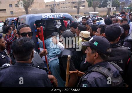 Hyderabad, Pakistan, 12. Juli 2023. Sicherheitsbeamte stellen den Baton-Angriff wieder her, benutzten Wasserkanonen und Verhaftungen, um Demonstranten abzuwehren, während sie sich während der Protestdemonstration der All Sindh Primary Teachers Association for Regularization am Mittwoch, den 12. Juli 2023 in Karatschi auf den Weg zum CM House bewegen. Stockfoto