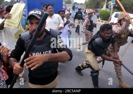 Hyderabad, Pakistan, 12. Juli 2023. Sicherheitsbeamte stellen den Baton-Angriff wieder her, benutzten Wasserkanonen und Verhaftungen, um Demonstranten abzuwehren, während sie sich während der Protestdemonstration der All Sindh Primary Teachers Association for Regularization am Mittwoch, den 12. Juli 2023 in Karatschi auf den Weg zum CM House bewegen. Stockfoto