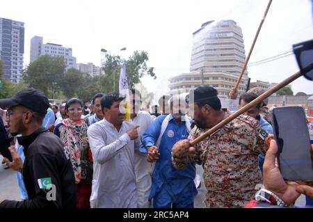 Hyderabad, Pakistan, 12. Juli 2023. Sicherheitsbeamte stellen den Baton-Angriff wieder her, benutzten Wasserkanonen und Verhaftungen, um Demonstranten abzuwehren, während sie sich während der Protestdemonstration der All Sindh Primary Teachers Association for Regularization am Mittwoch, den 12. Juli 2023 in Karatschi auf den Weg zum CM House bewegen. Stockfoto