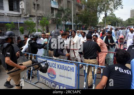 Hyderabad, Pakistan, 12. Juli 2023. Sicherheitsbeamte stellen den Baton-Angriff wieder her, benutzten Wasserkanonen und Verhaftungen, um Demonstranten abzuwehren, während sie sich während der Protestdemonstration der All Sindh Primary Teachers Association for Regularization am Mittwoch, den 12. Juli 2023 in Karatschi auf den Weg zum CM House bewegen. Stockfoto